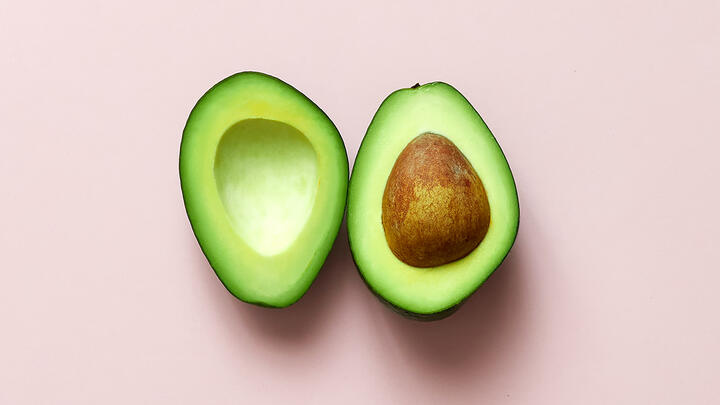 What is avocado intolerance? Halved avocado on a pink surface