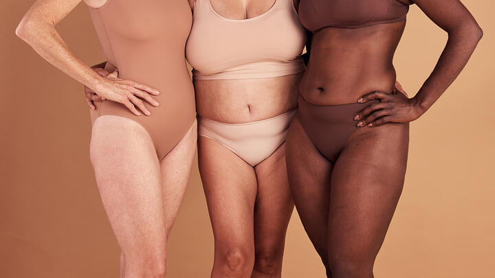 Big-tent beauty is a concept of beauty where everyone is welcome and everyone is beautiful. Closeup of lower parts of three women's bodies of various ages, constitutions, and skin colors.